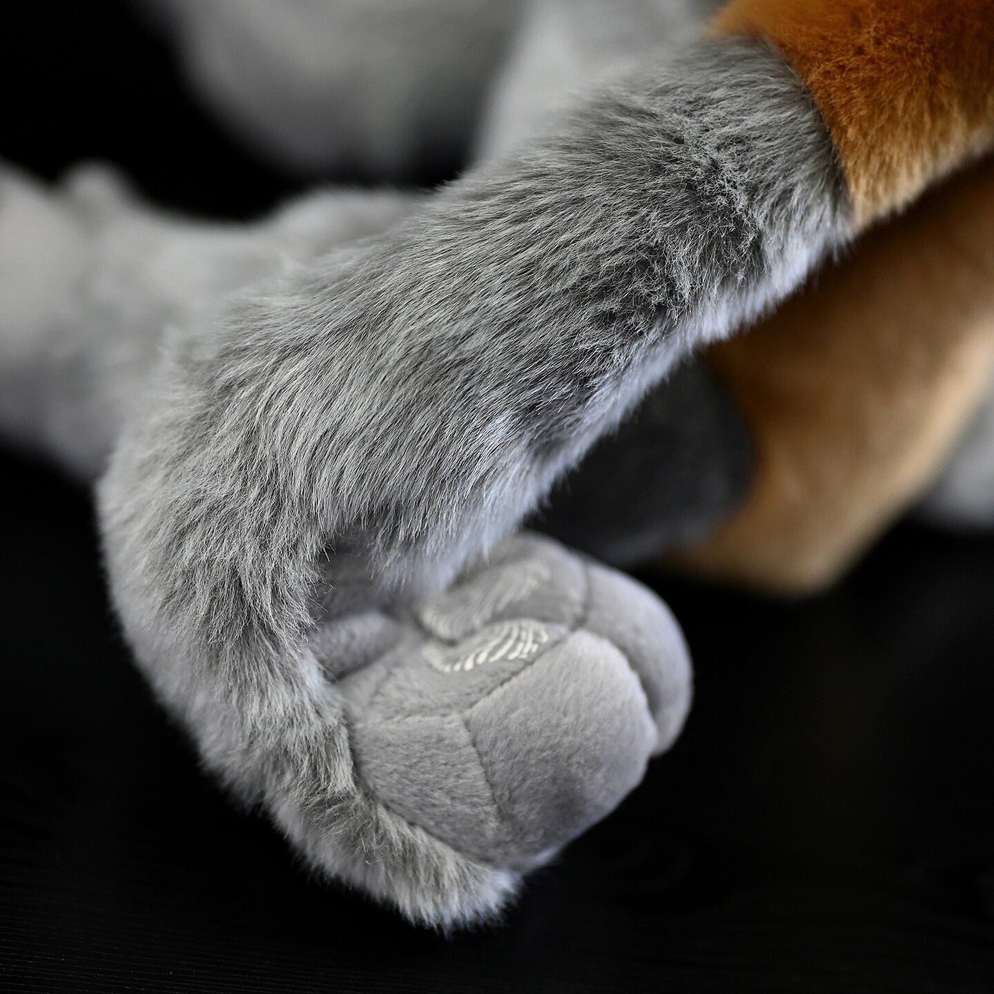 Detailed close-up of the plush Proboscis Monkey's hand, showcasing fine sewing and soft textures
