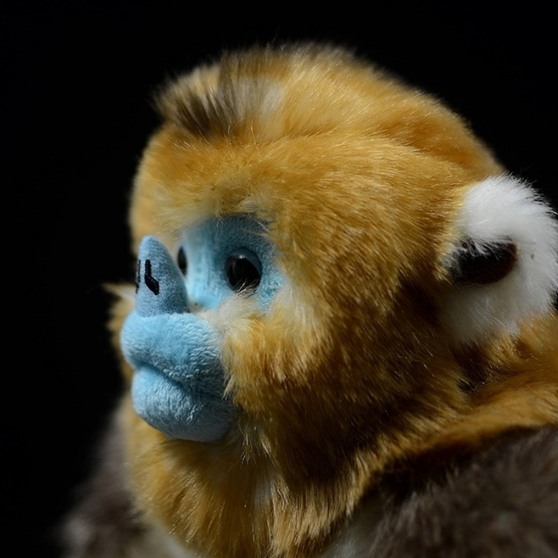 Close-up of a golden snub-nosed monkey plush toy’s face, highlighting its blue nose and expressive eyes by SoftDaysLab