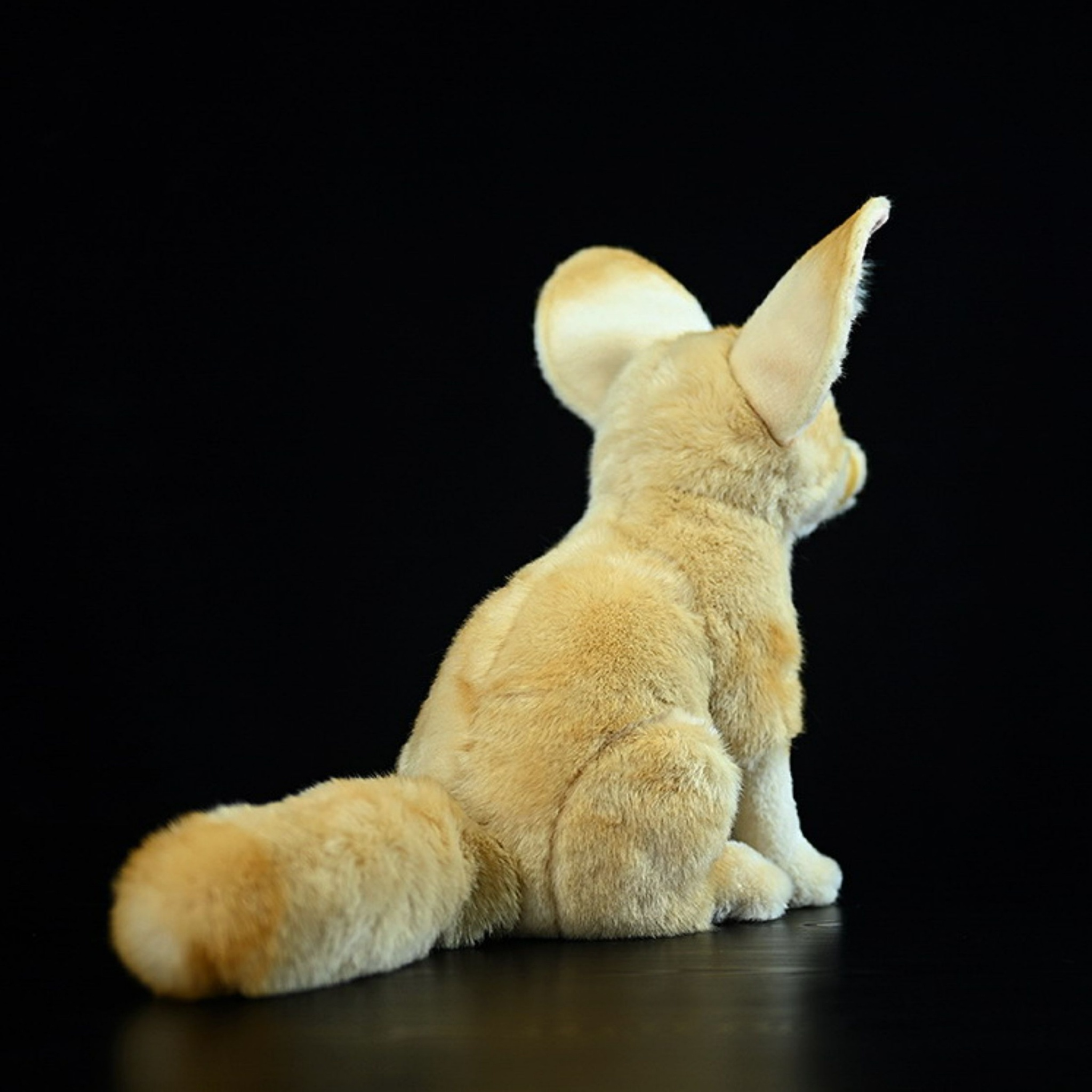 Rear view of a soft fennec fox plush toy with a fluffy tail and realistic texture