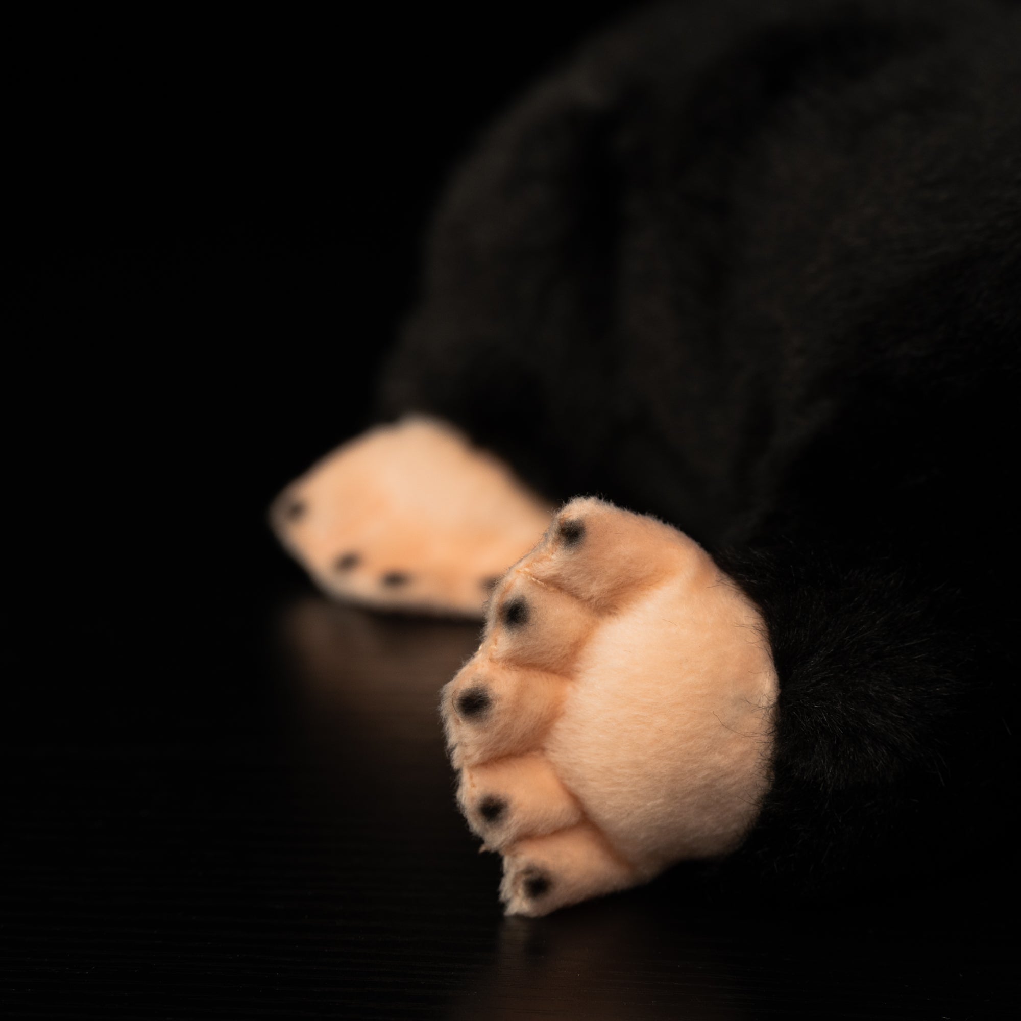 Detailed view of mole plush toy's soft front paws, showcasing its digging adaptations