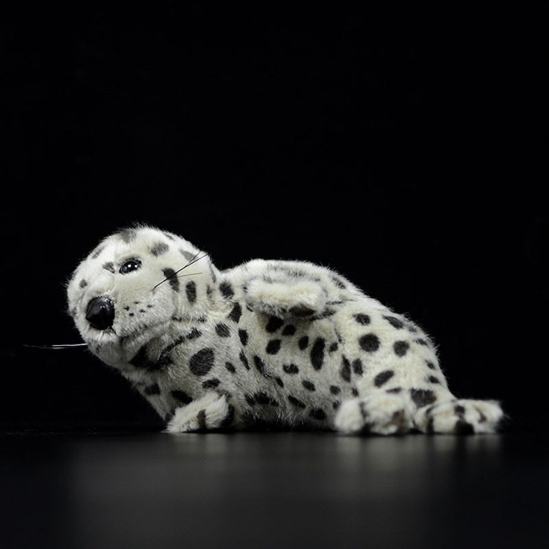 Lifelike spotted seal pup plush lying on its side, designed for marine animal enthusiasts by SoftDaysLab