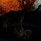 Close-up of the red panda plush toy's fur texture, showcasing its soft and vibrant orange and brown colors