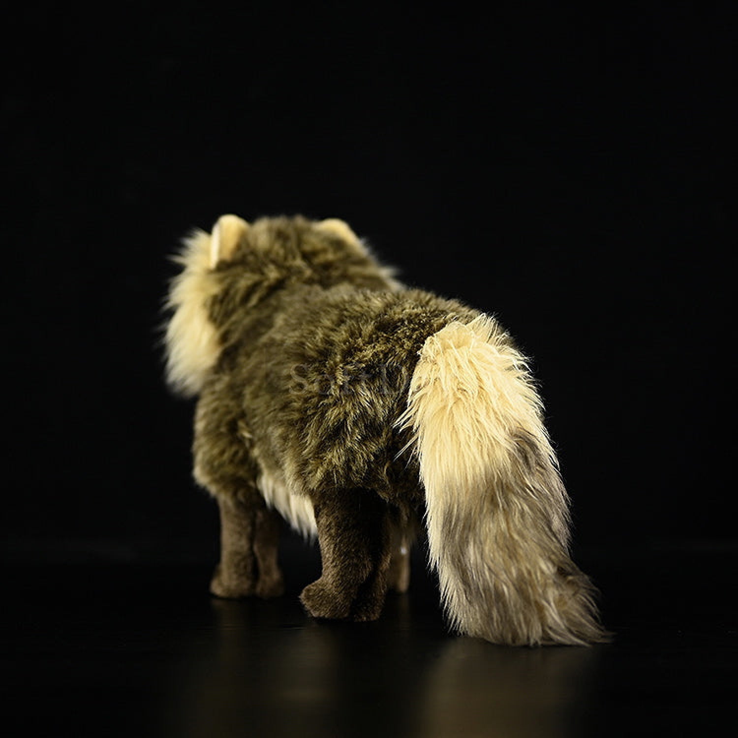 Rear view of lifelike Japanese raccoon dog plush toy, showcasing its fluffy tail and lifelike design