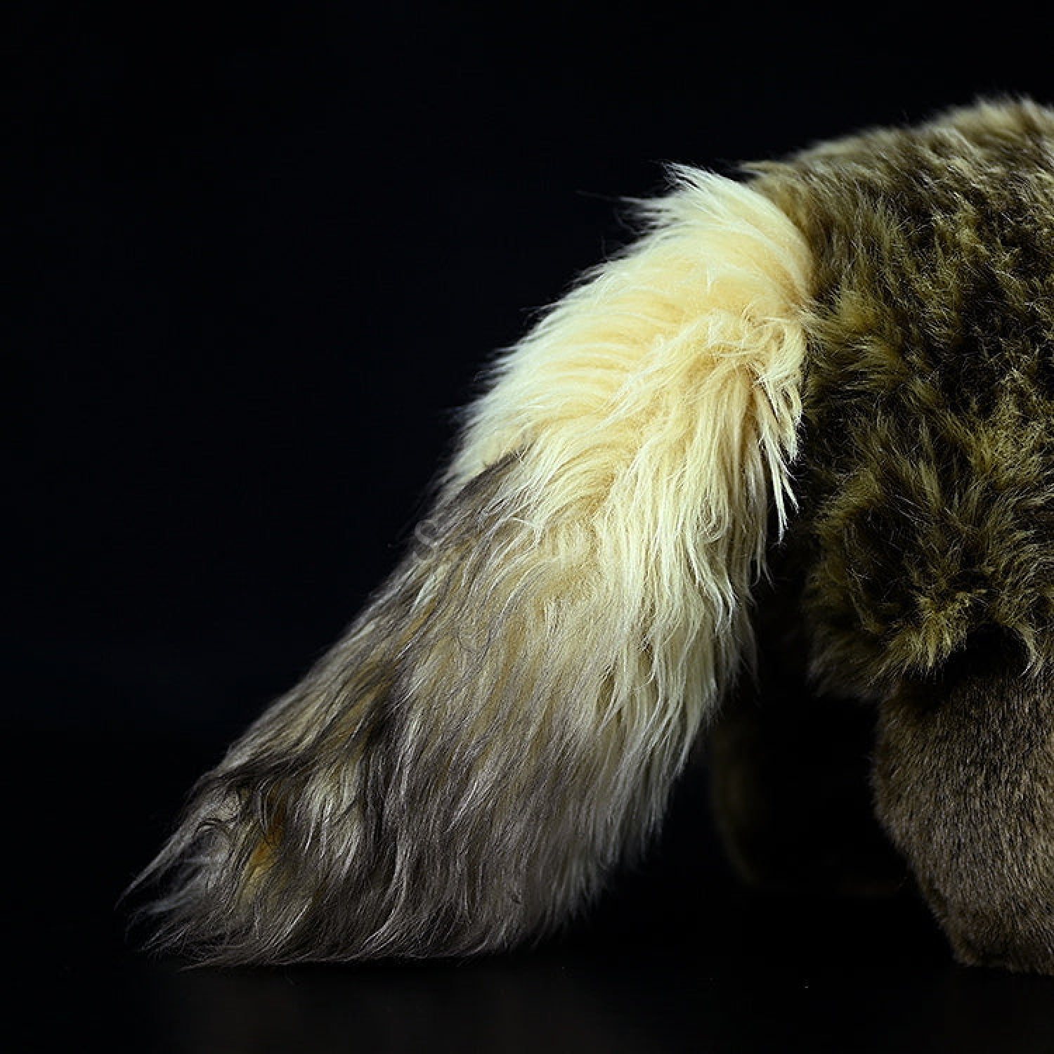 Close-up of Japanese raccoon dog plush toy’s fluffy tail with realistic color and texture details