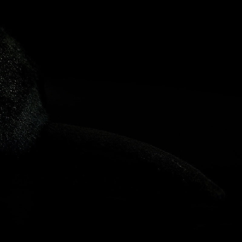Close-up of the black rat plush's tail, revealing the authentic design and smooth texture