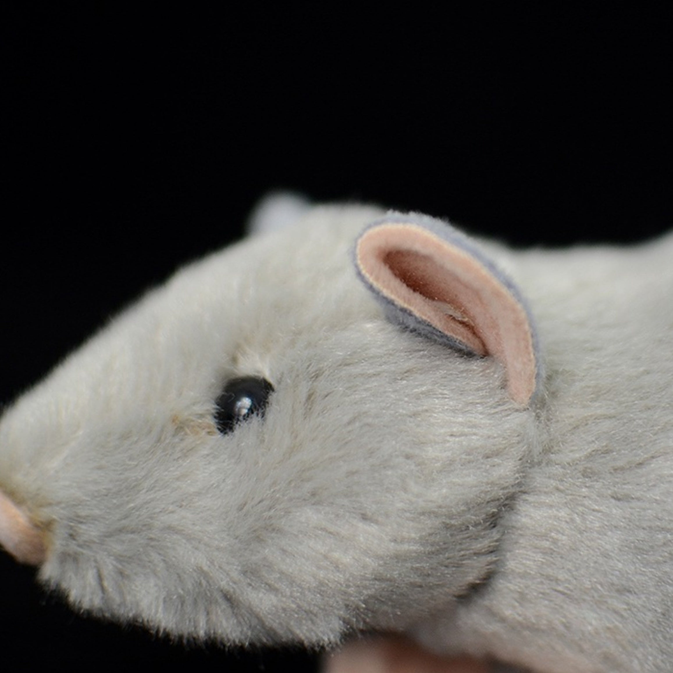 Close-up of the grey mouse plush toy's ear and face, showcasing intricate and realistic details