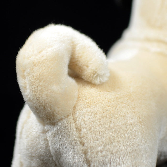 Detailed image of the fawn pug plush’s curled tail, showcasing its fluffy and lifelike design