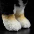 Close-up of Black & Tan Shiba Inu plush toy paws with soft fur and realistic tan markings