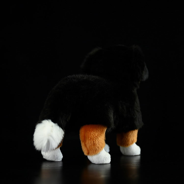 Back view of a Bernese Mountain Dog plush toy, showcasing its fluffy tail and soft tricolor coat