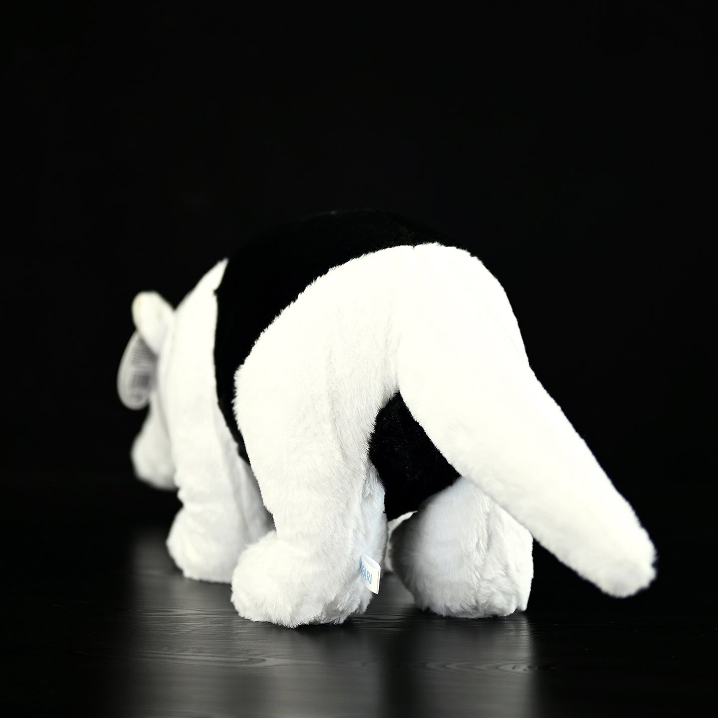 Rear view of a Southern Tamandua plush toy, showing its lifelike tail and soft texture