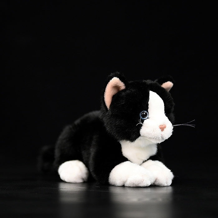 Lifelike Tuxedo Cat plush toy lying down, featuring soft black-and-white fur by SoftDaysLab
