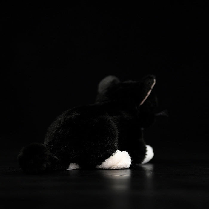 Back view of a Tuxedo Cat plush toy, highlighting its fluffy tail and lifelike black-and-white fur