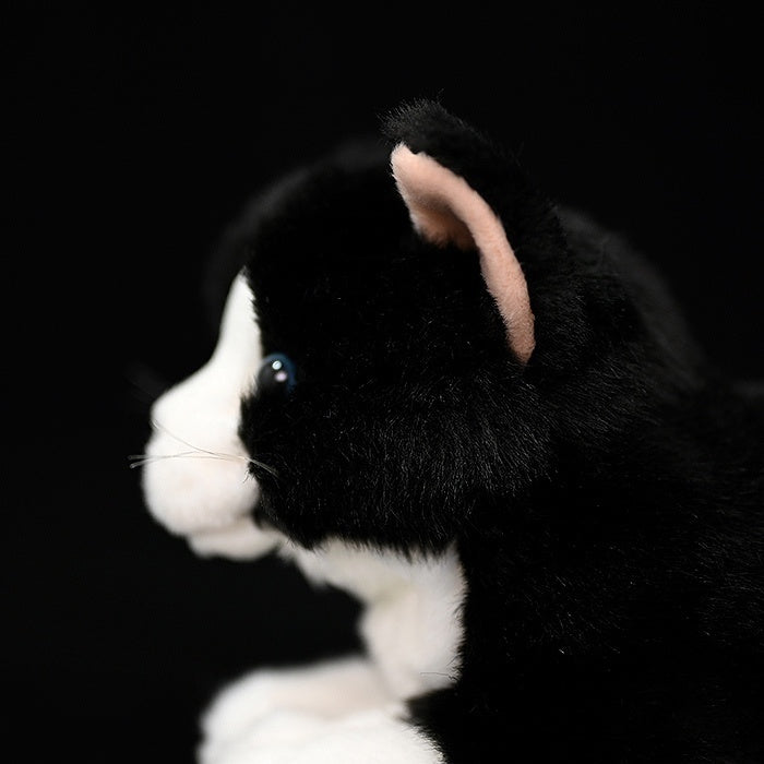 Side close-up of the Tuxedo Cat plush toy, showing its realistic ear and soft black-and-white fur