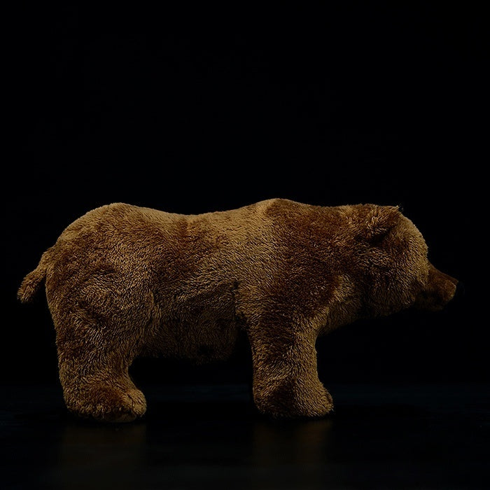 Side view of a realistic brown bear plush toy, showcasing lifelike details and soft brown fur