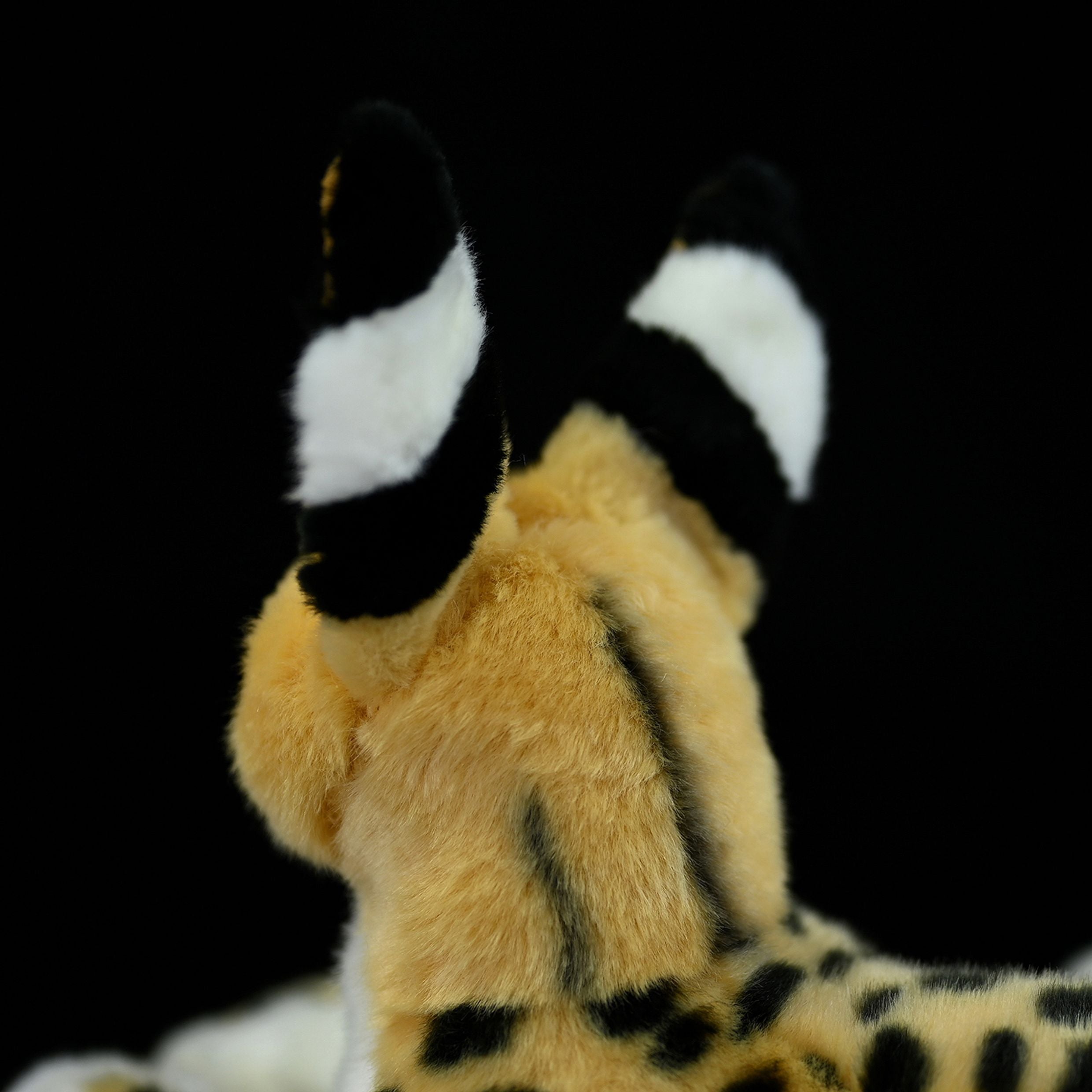 Rear close-up of the serval cat plush toy’s black-tipped ears with white stripes