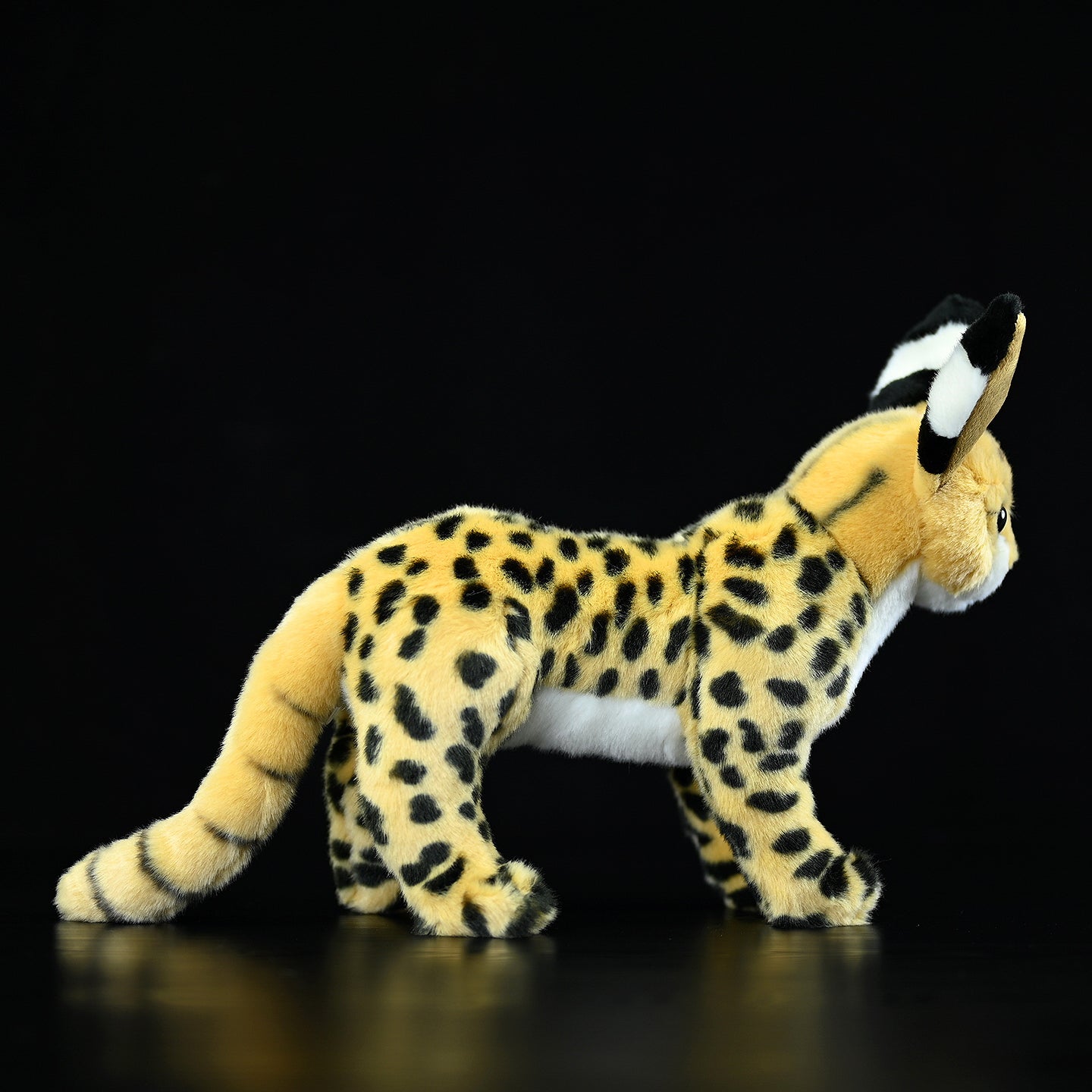 Side view of a standing serval cat plush toy showcasing its lifelike design and spotted golden fur