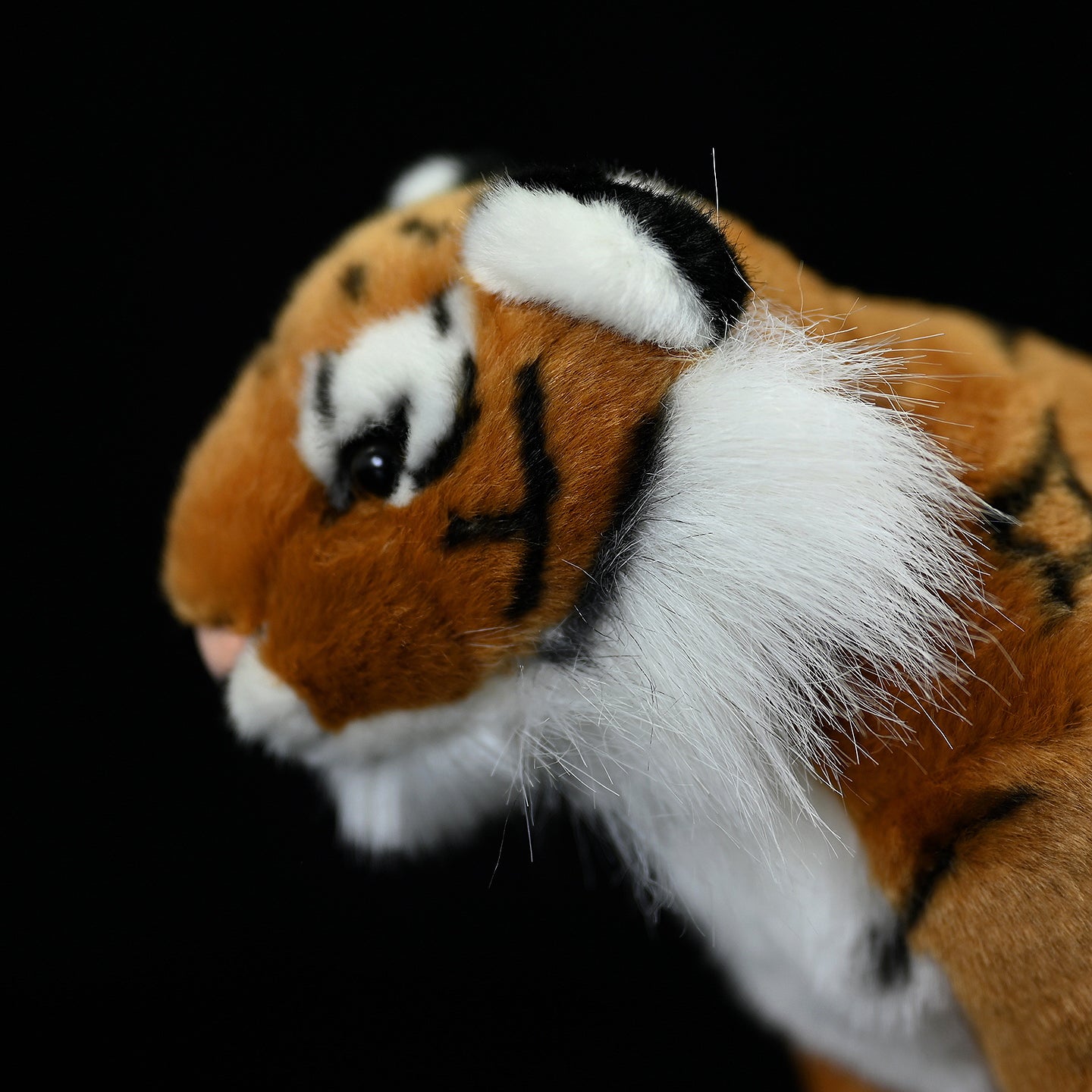 Close-up of tiger plush toy's head, capturing its lifelike features and detailed craftsmanship