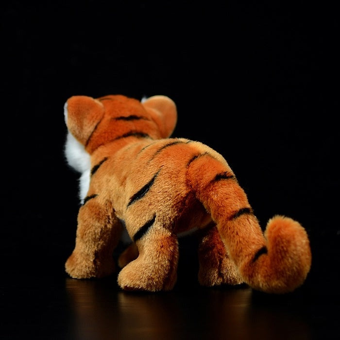 Back view of a tiger cub plush toy, highlighting its soft fur and detailed striped tail