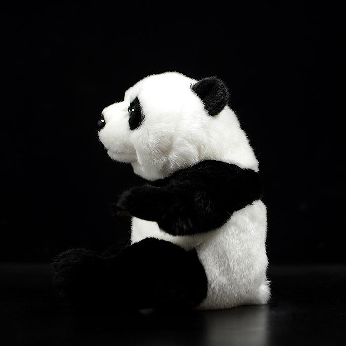 Side profile of a realistic giant panda plush toy, highlighting its thick fur and cuddly design