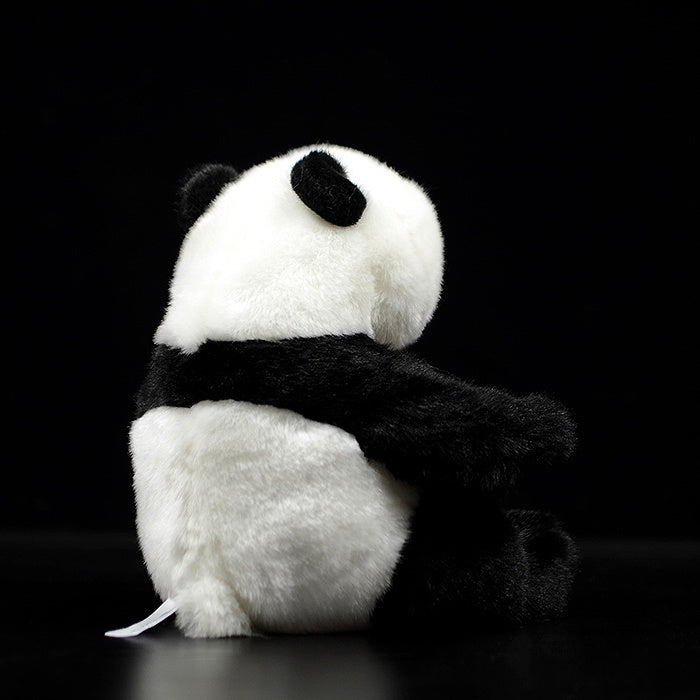Back view of a giant panda plush toy, showing its fluffy tail and detailed craftsmanship
