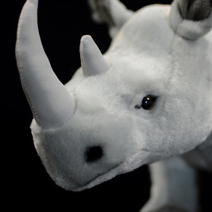 Detailed close-up of a white rhinoceros plush toy's head, featuring its adorable and realistic facial details
