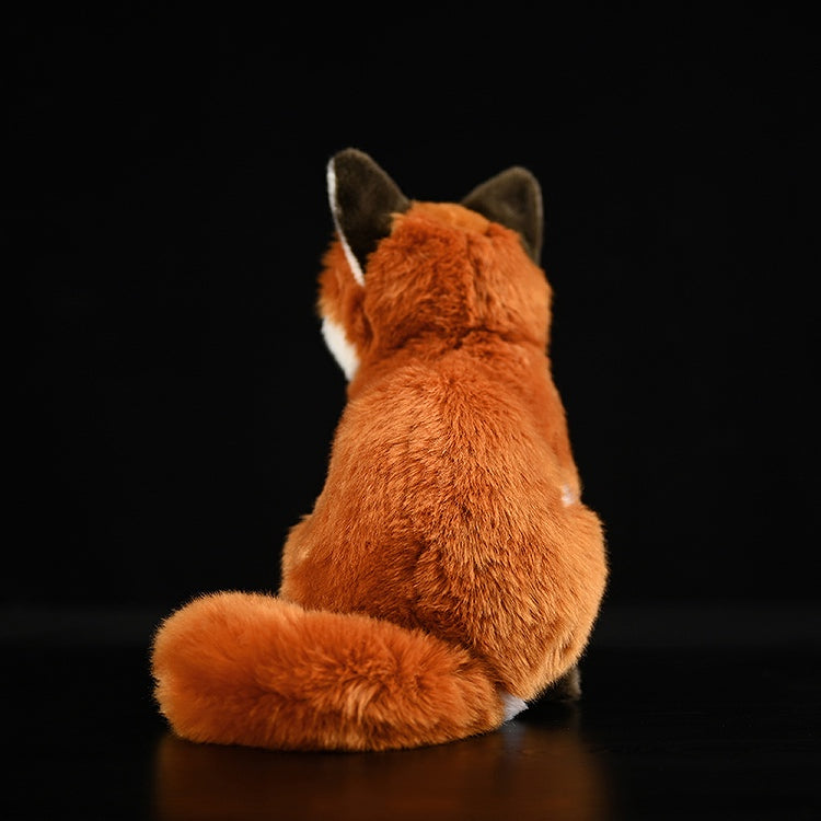 Rear view of the lifelike red fox plush toy, highlighting its fluffy tail and soft, huggable fur