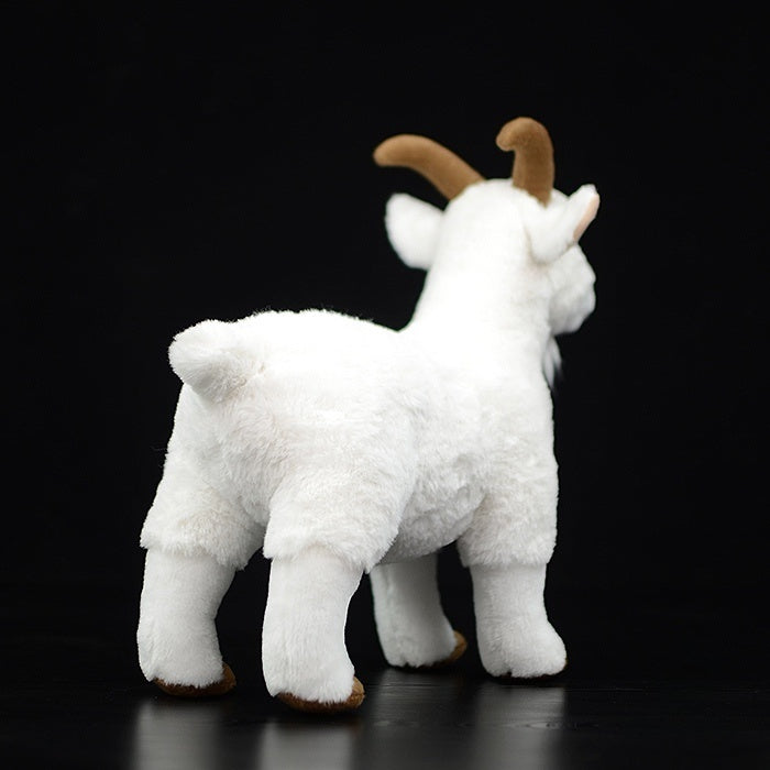 Back view of a white goat plush toy, showing its soft texture and fluffy tail