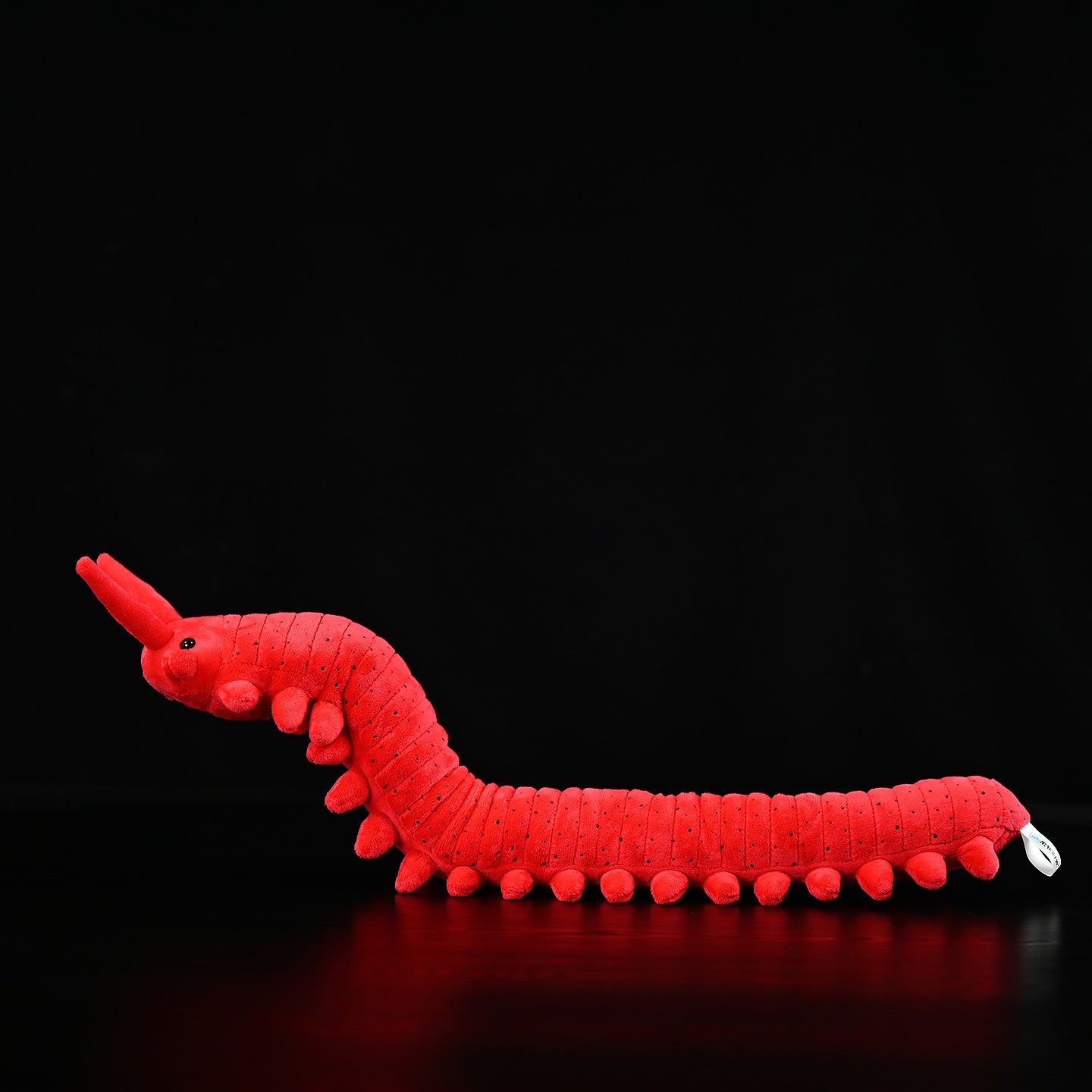 Full side profile of the velvet worm plush toy, featuring its realistic red body and soft legs by SoftDaysLab