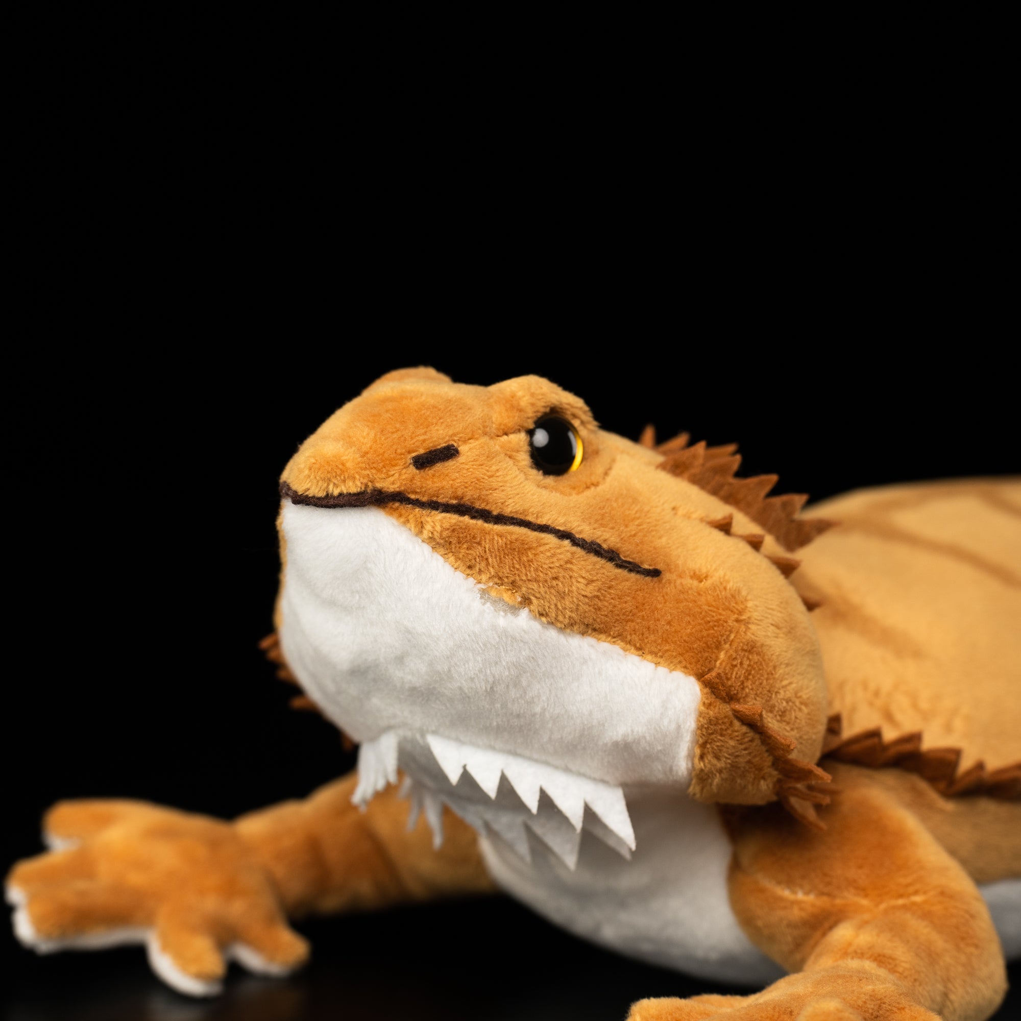 Close-up of bearded dragon plush toy's lifelike facial features, eyes, and soft snout by SoftDaysLab