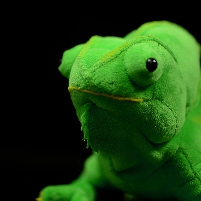 Close-up of plush green chameleon's face, showcasing detailed stitching and expressive black eyes