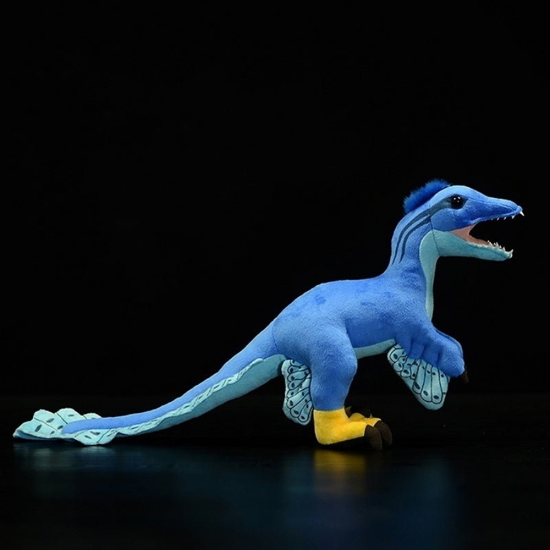 Side profile of Microraptor dinosaur plush toy with vibrant blue body and four-winged features
