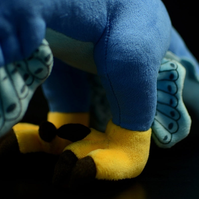 Feet close-up of Microraptor dinosaur plush toy showing vibrant colors and soft, cuddly texture