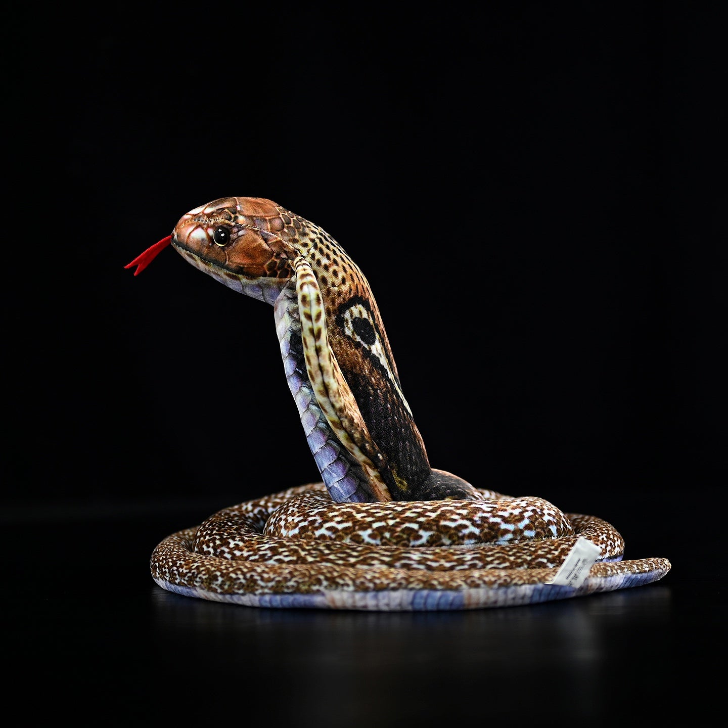 Side view of the striking monocled cobra plush toy, featuring a raised hood and coiled body in realistic design