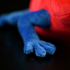 Close-up of the lifelike plush leg of Strawberry Poison Dart Frog, showcasing its realistic texture