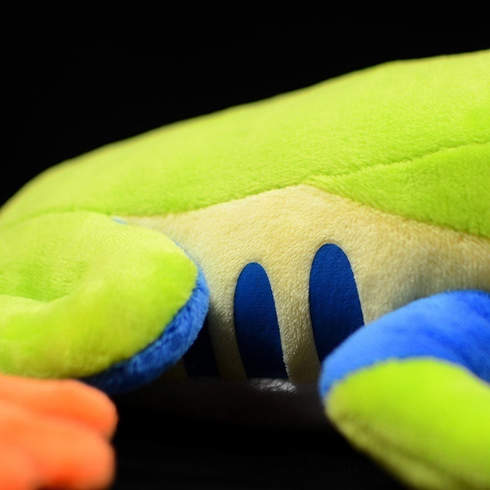 Close-up of the plush frog’s body, showing blue side patterns and soft green fabric