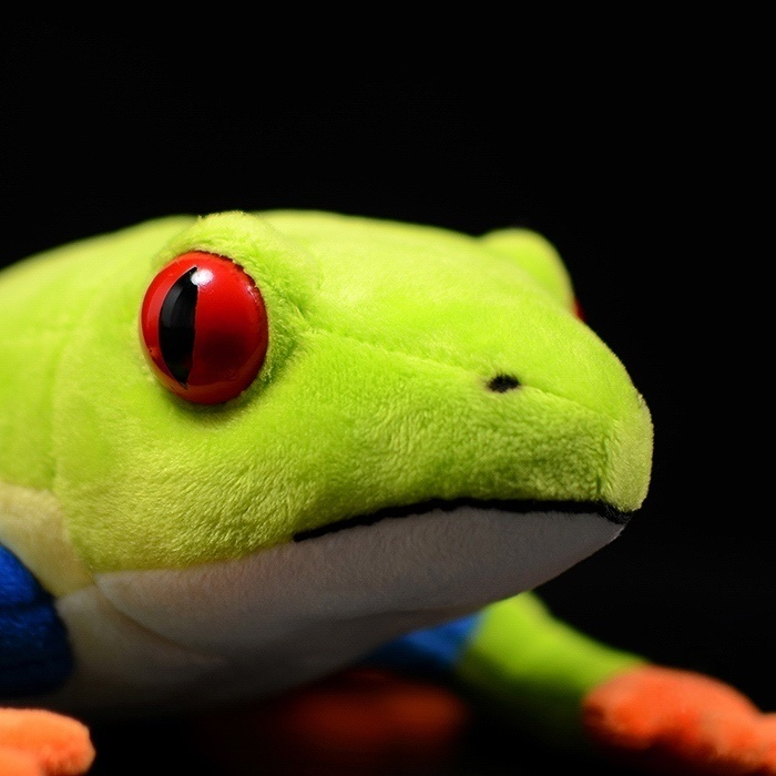 Detailed view of the Red-Eyed Tree Frog plush's realistic head with striking red eyes