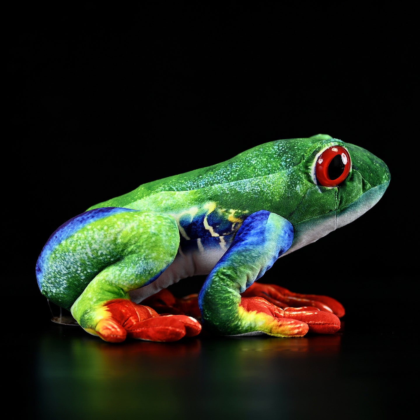 Side profile of an ultra-realistic red-eyed tree frog plush with vibrant colors and realistic texture