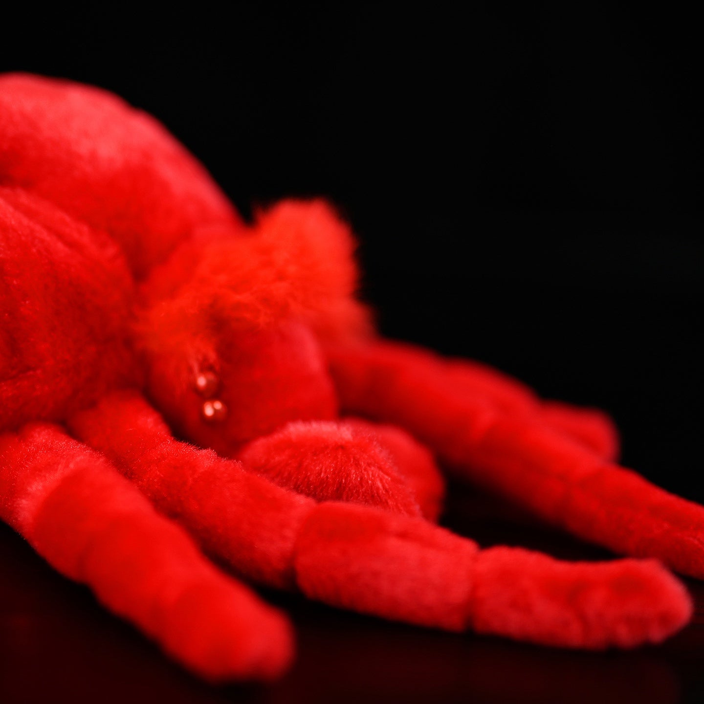 Detailed close-up of red velvet mite plush face, highlighting soft fur and intricate craftsmanship