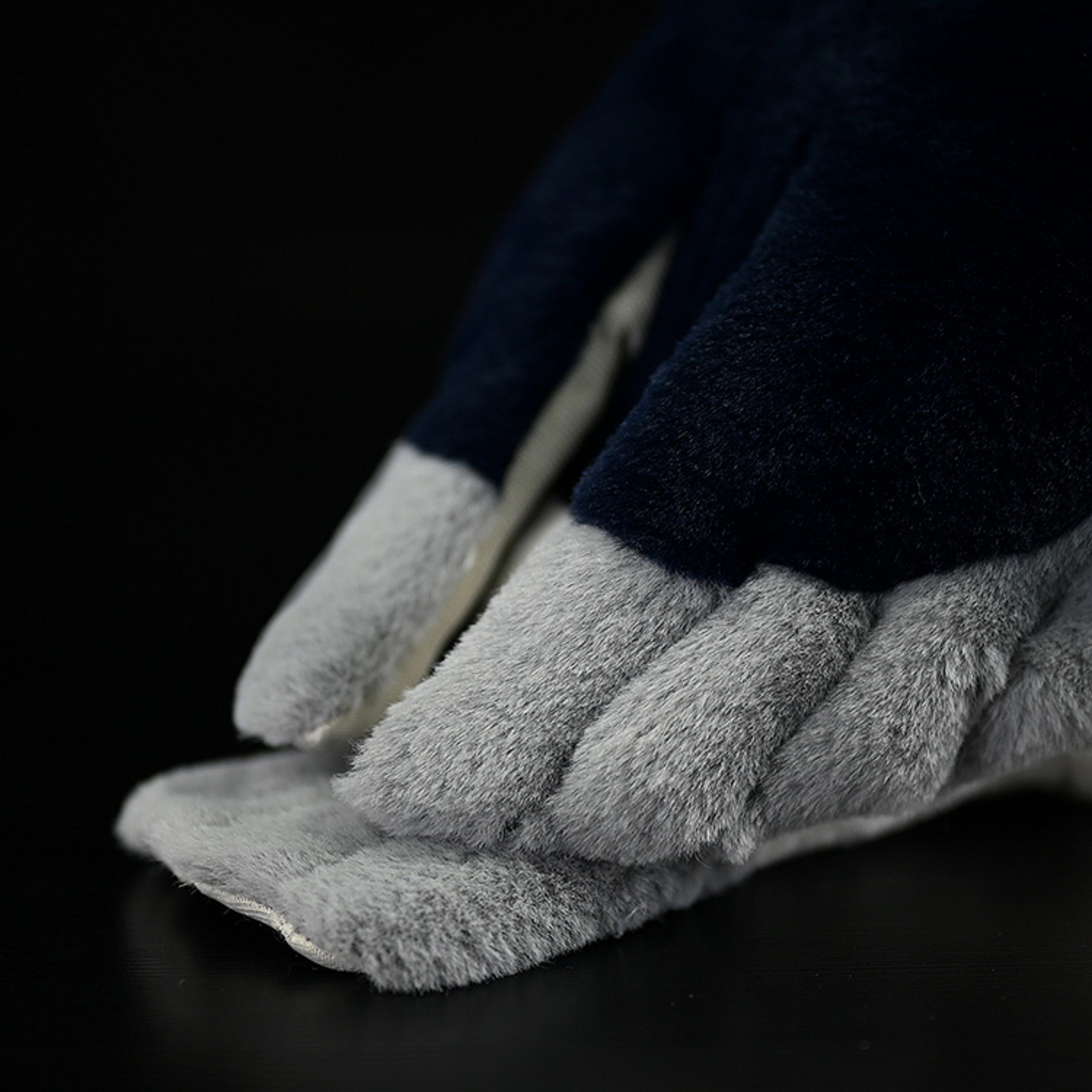 Close-up of the plush tail of a Black-crowned Night Heron toy, showcasing soft gray and black textures
