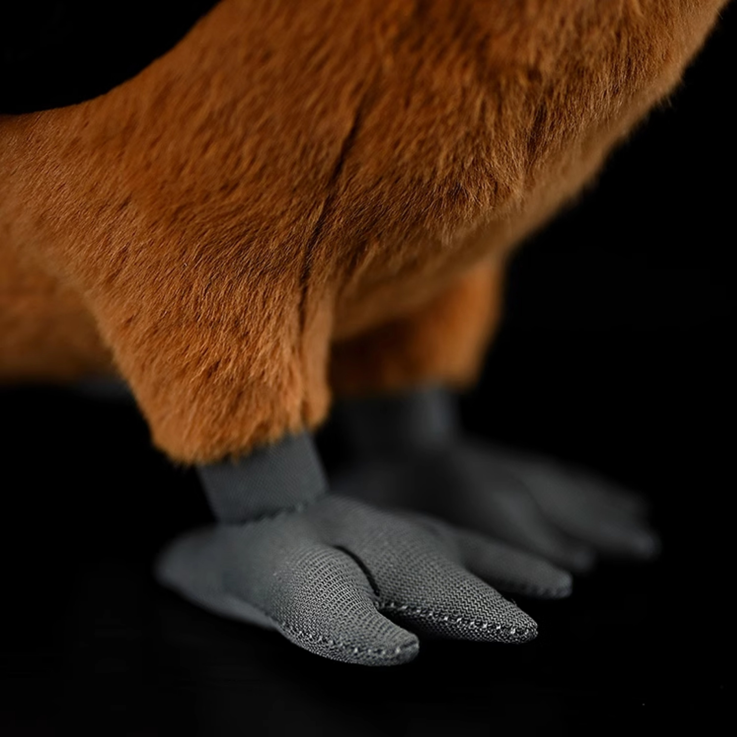 Close-up of the soft grey feet of the Rufous-necked Hornbill plush toy, capturing lifelike details