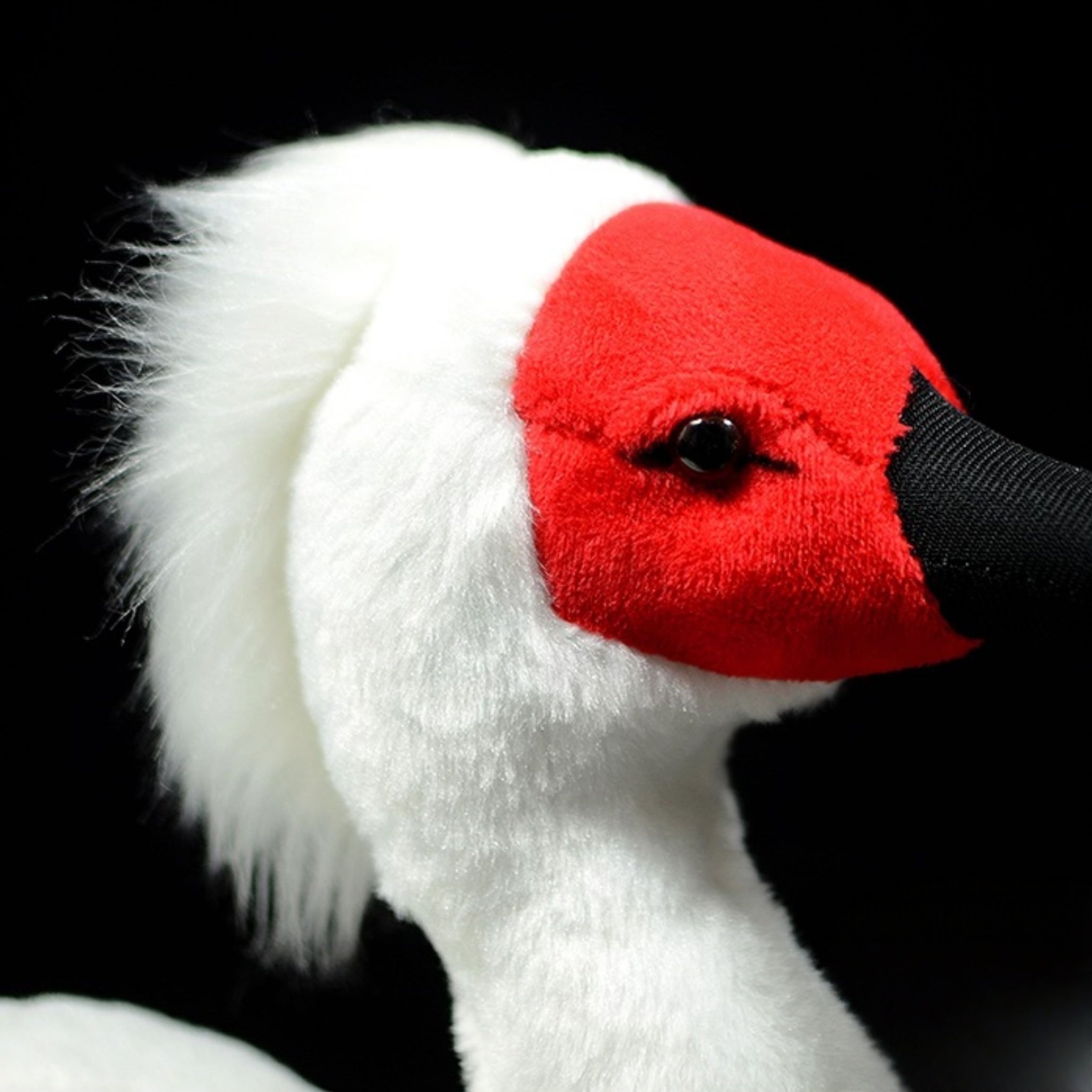 Close-up of the soft and fluffy head of the Asian crested ibis plush, highlighting lifelike red face and texture