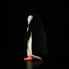 Rear view of a chinstrap penguin plush toy, highlighting its soft tail and realistic black-and-white coloring