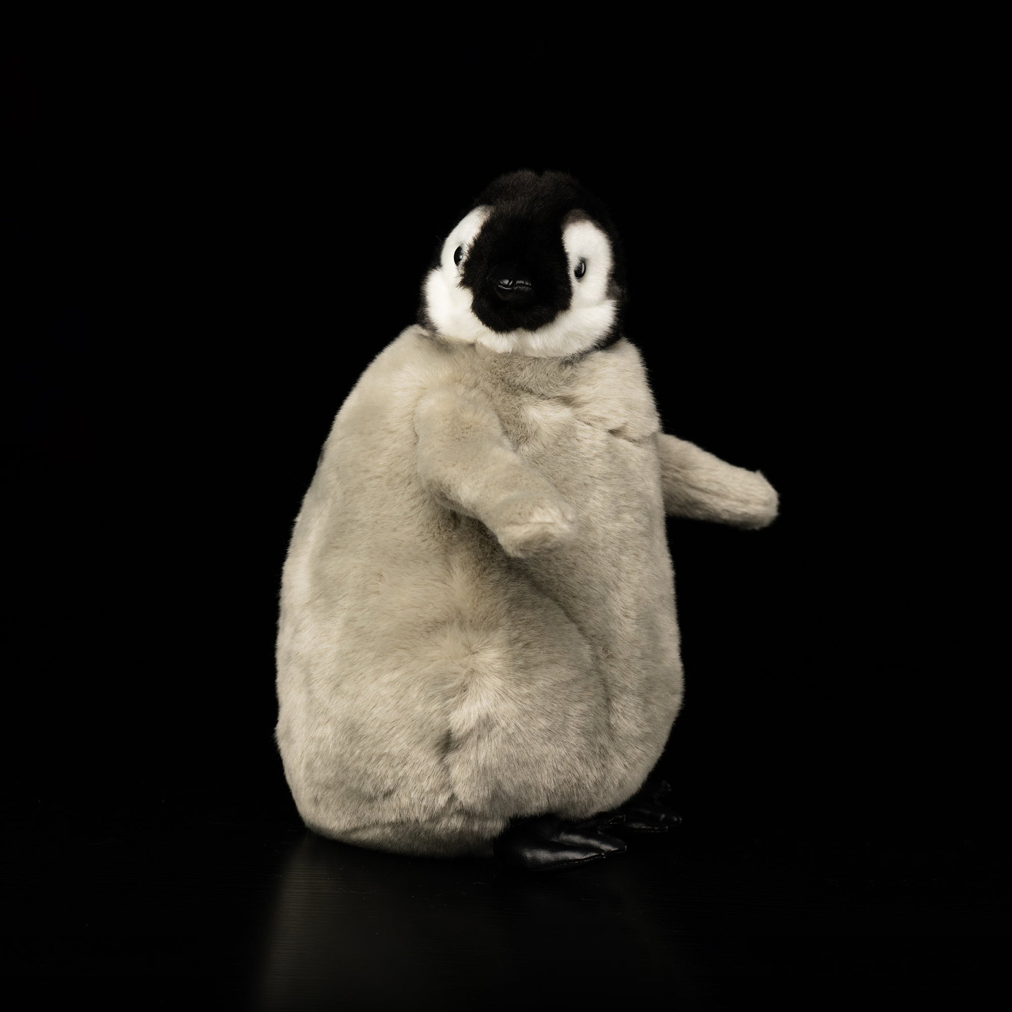 Side-angle view of lifelike Emperor Penguin chick plush by SoftDaysLab®, with rotatable head feature
