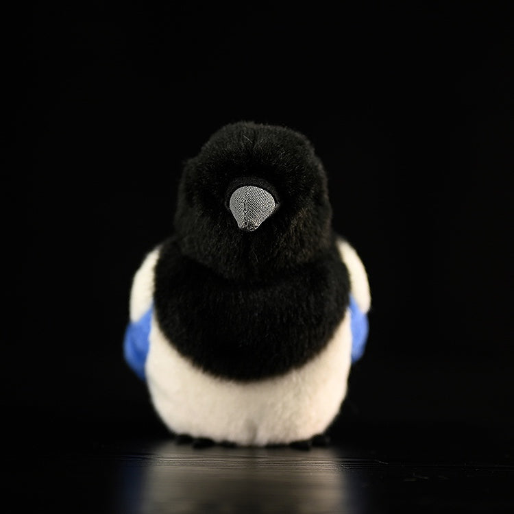 Rear view of a black-billed magpie plush toy, showcasing its chubby design and lifelike black-and-white details