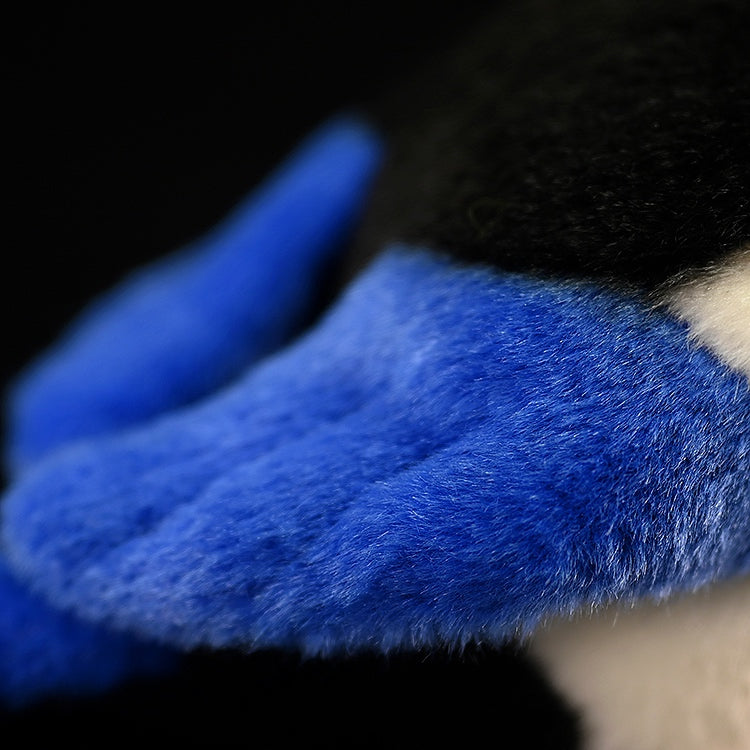 Close-up of the black-billed magpie plush toy's wing, showcasing its soft, vibrant blue texture and realistic design