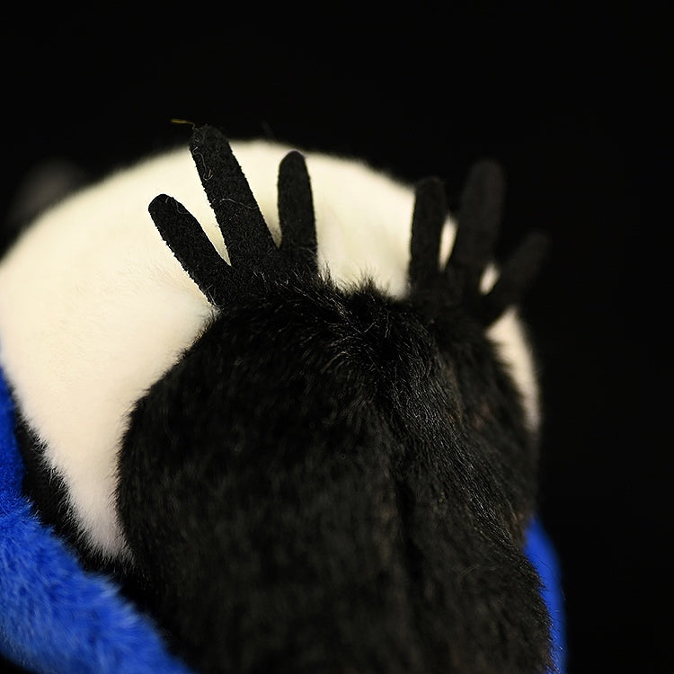 Close-up of the detailed claws and soft black feathers of a black-billed magpie plush toy, emphasizing its craftsmanship
