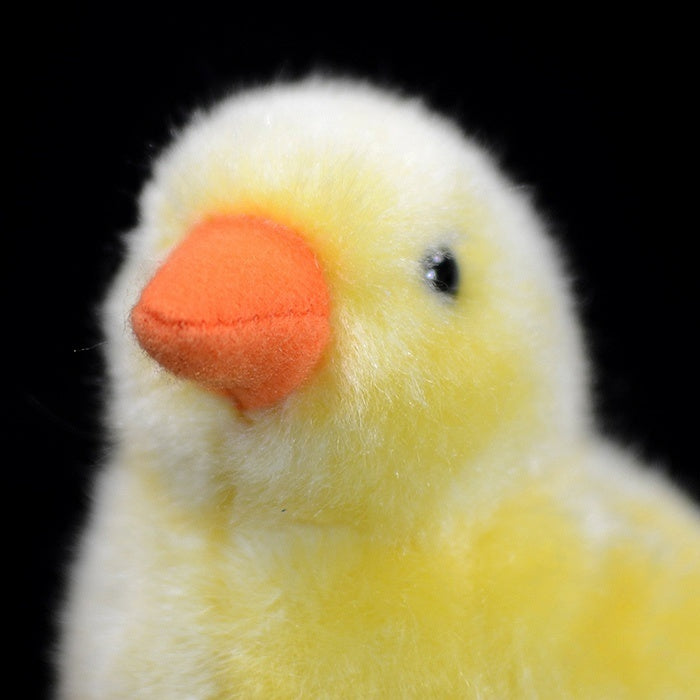 Close-up of the yellow chick plush toy's face, featuring a detailed orange beak and lifelike design