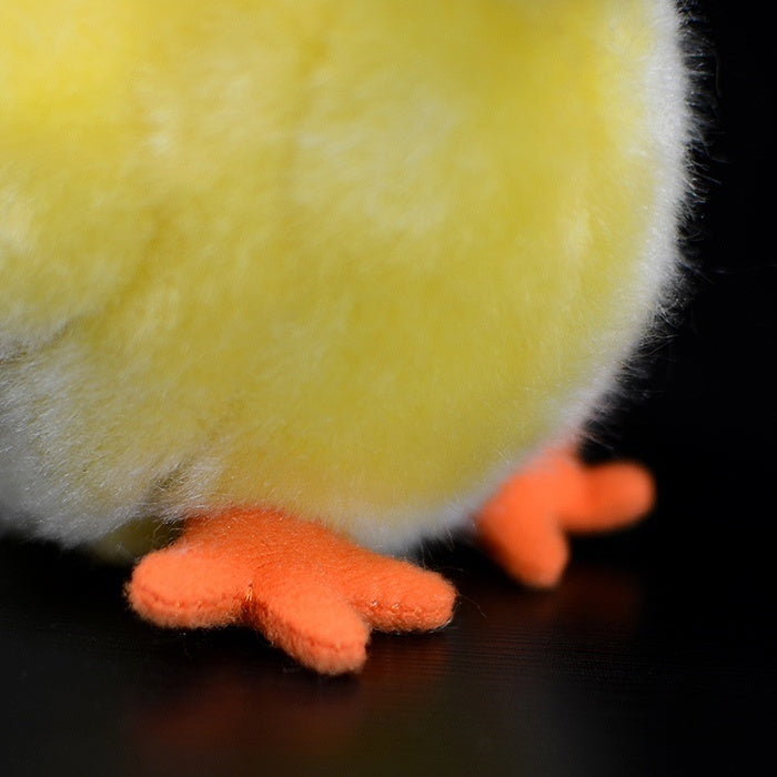 Close-up of the plush chick's orange feet, crafted with realistic details and soft materials