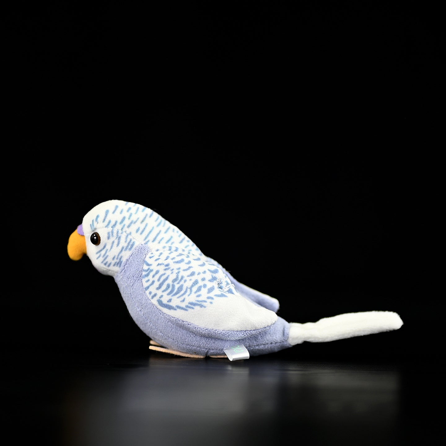 Profile view of adorable violet budgerigar plush toy with soft textures and authentic patterns