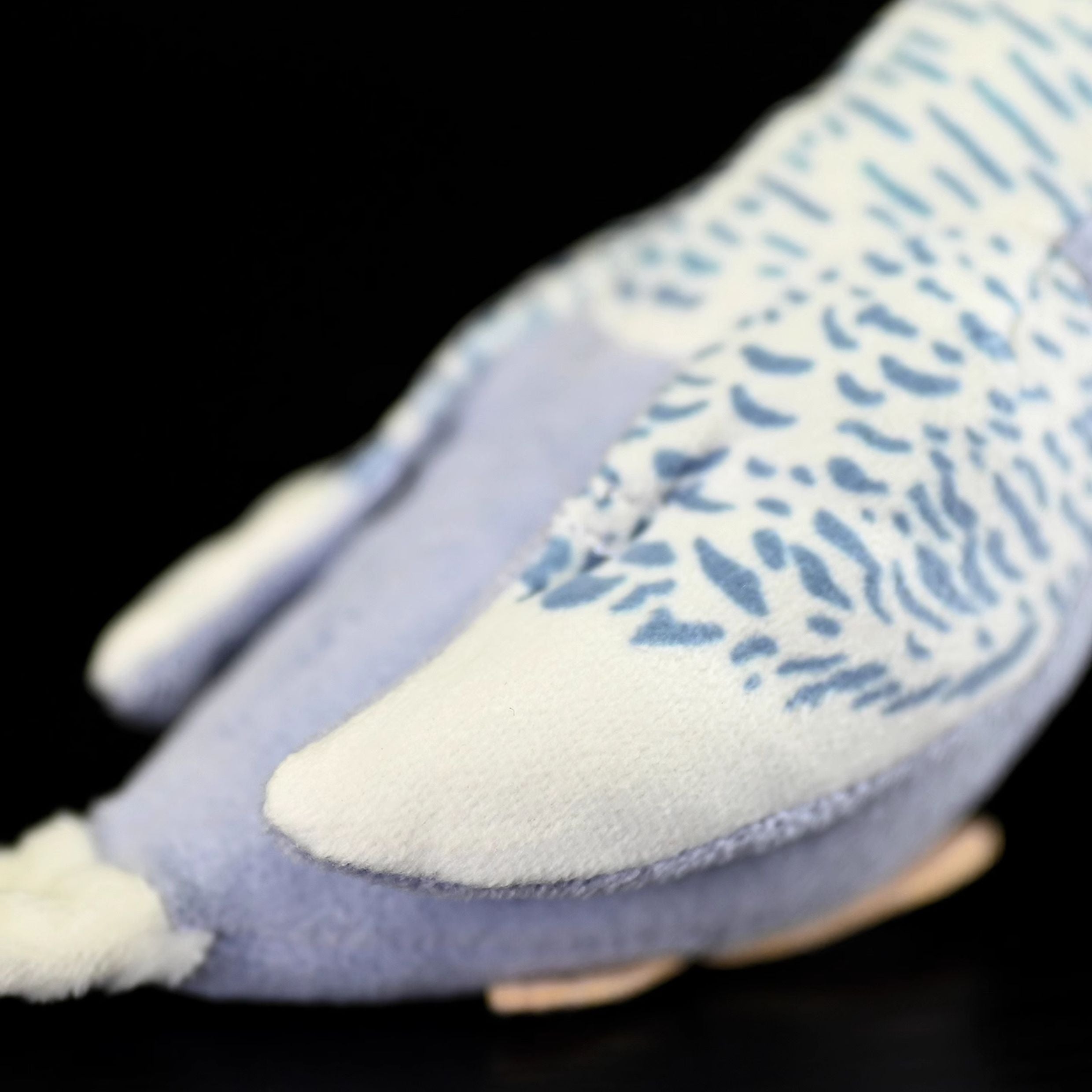 Close-up of the violet budgerigar plush toy's detailed wings with realistic blue and white patterns